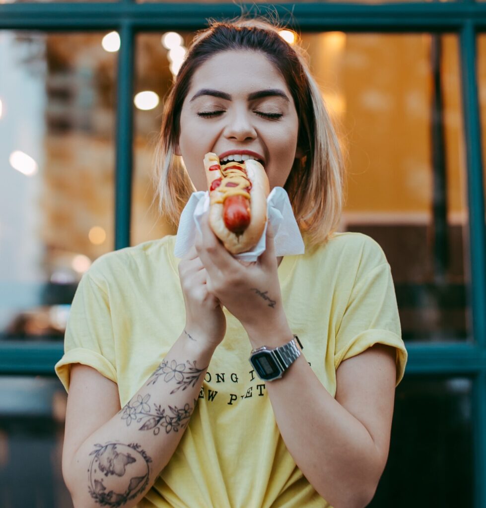 Woman having a hot dog. Purchase by impulse