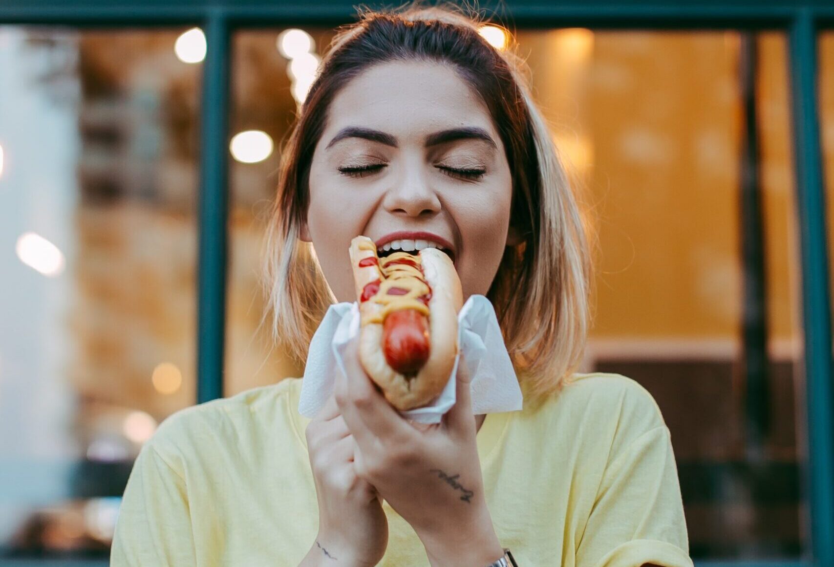 Woman having a hot dog. Purchase by impulse