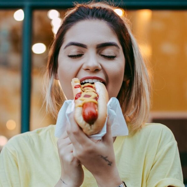Woman having a hot dog. Purchase by impulse